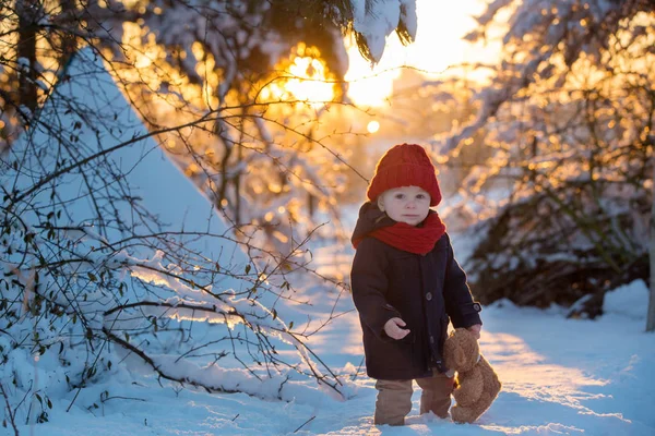 Baby spelen met teddy in de sneeuw, winter tijd. Kleine peuter — Stockfoto