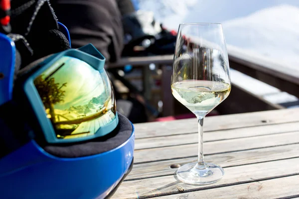 Refleksioner af snedækket bjerg i hjelm og et glas vin på t - Stock-foto