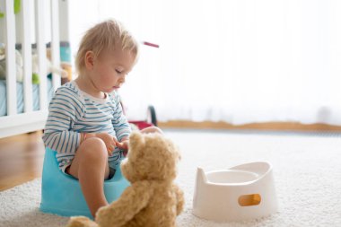 Sevimli Toddler çocuk, lazımlık eğitim, onun oyuncak ayı ile oynuyor 