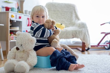 Sevimli Toddler çocuk, lazımlık eğitim, onun oyuncak ayı ile oynuyor 
