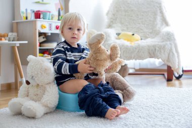 Sevimli Toddler çocuk, lazımlık eğitim, onun oyuncak ayı ile oynuyor 