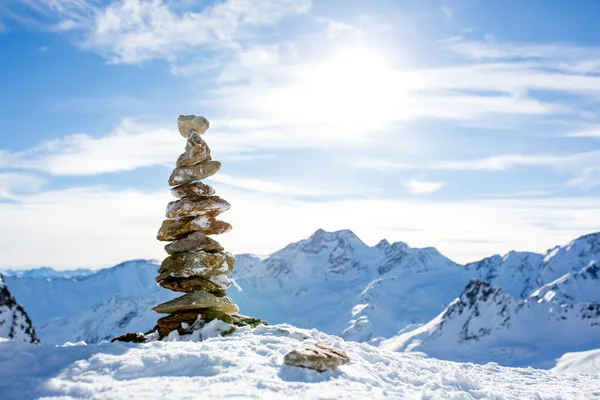 Steinhaufen auf dem Gipfel des Berges bei Sonnenuntergang, Schnee und blauem Himmel — Stockfoto