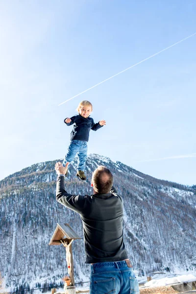 Маленький мальчик, летящий в небе, отец бросает его высоко в — стоковое фото