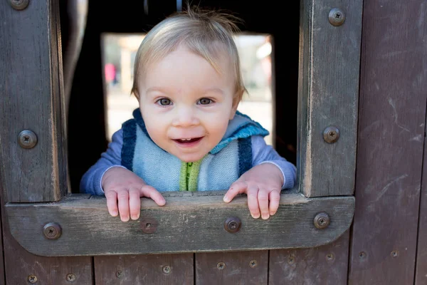 Divertente carino felice bambino che gioca nel parco giochi, all'aperto. Ah! — Foto Stock