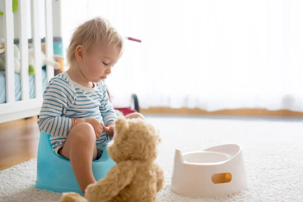 Menino bonito da criança, treinamento potty, brincando com seu ursinho de pelúcia — Fotografia de Stock