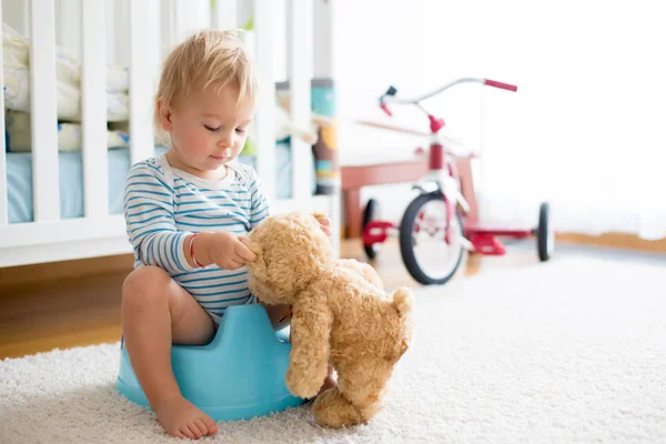 Carino bambino ragazzo, mostrando la sua orsacchiotto amico come per pipì in po — Foto Stock