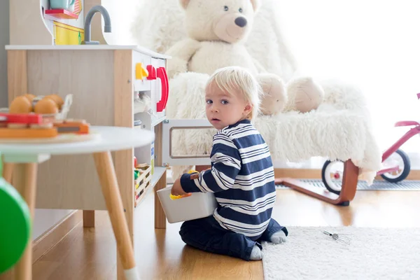 Menino da criança doce, brincando com cozinha de madeira e brinquedos — Fotografia de Stock