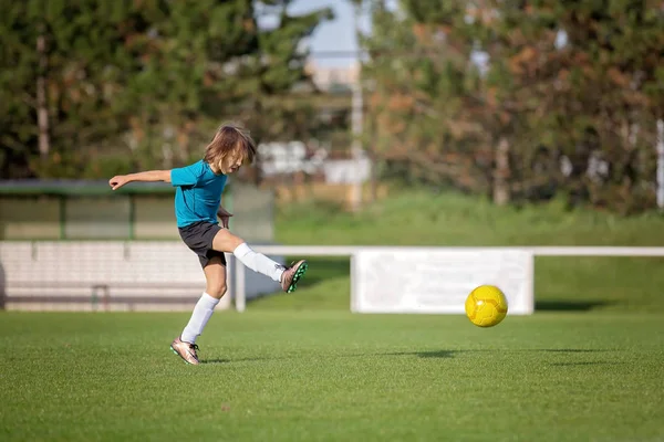 Mały chłopiec maluch, bawi się piłką nożną na placu zabaw w th — Zdjęcie stockowe