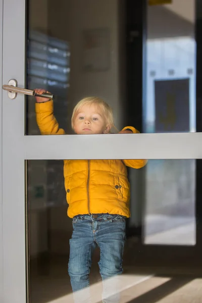 Ребенок-блондин в желтой куртке, играющий сзади — стоковое фото