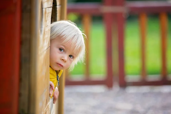 Petit enfant blond en veste jaune, jouant sur le pla — Photo