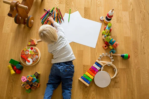 Kleine blonde peuter jongen, tekening met pastels en kleurpen — Stockfoto