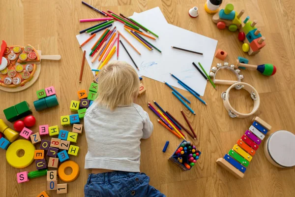 Маленький блондинка мальчик, рисунок с пастелью и цветной ручкой — стоковое фото