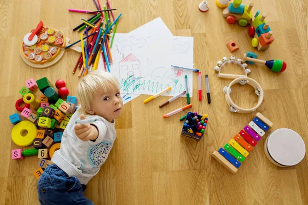 小さなブロンドの幼児の男の子、パステルと着色ペンで描く — ストック写真