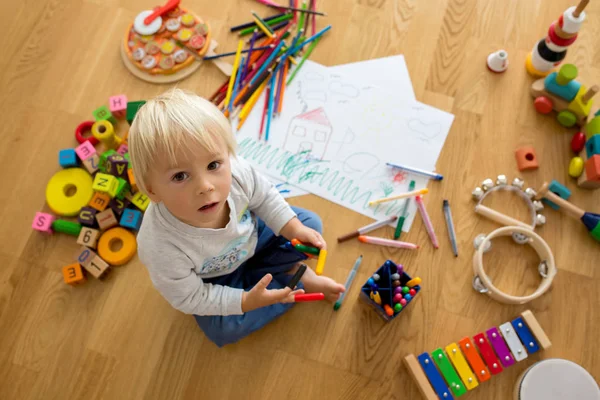 小さなブロンドの幼児の男の子、パステルと着色ペンで描く — ストック写真