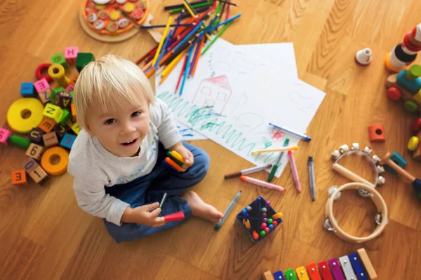 Pequeño niño rubio, dibujo con pasteles y pluma para colorear —  Fotos de Stock