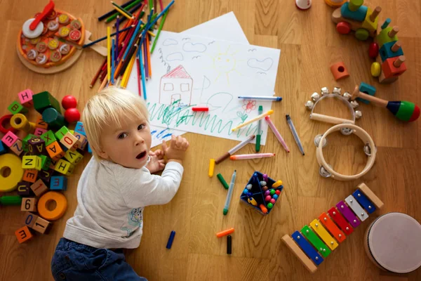 Маленький блондинка мальчик, рисунок с пастелью и цветной ручкой — стоковое фото