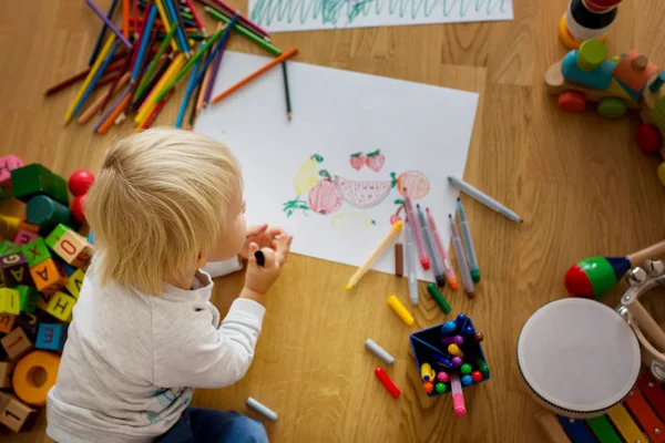 Piccolo bambino biondo, disegno con pastelli e penna da colorare — Foto Stock