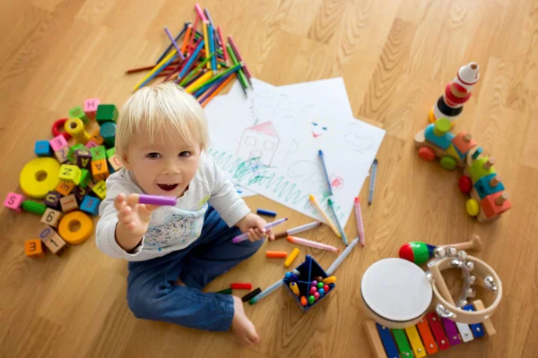 Pastel boyalı kalemle resim çizen küçük sarışın çocuk. — Stok fotoğraf
