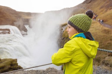 Çocuklar, Mounta 'daki görkemli Gullfoss şelalesinin tadını çıkarıyorlar.