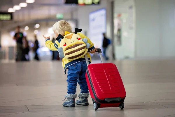 Netter kleiner Junge wartet auf den Flug in der Transithalle des Flughafens — Stockfoto