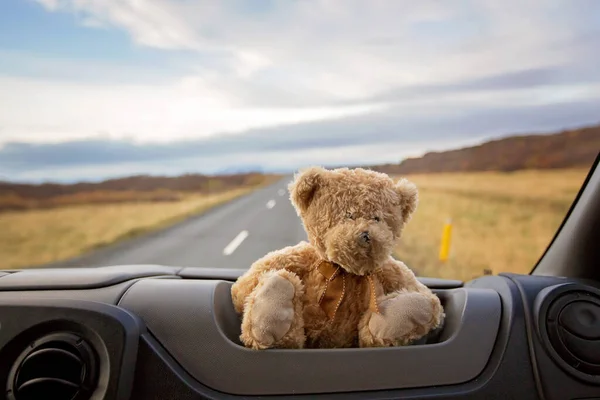 Teddy urso, sentado no pára-brisas dianteiro de uma van campista, peo — Fotografia de Stock