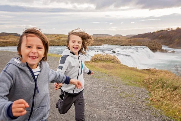 Porträt fröhlich rennender Kinder, Knabenbrüder, nahe kleinerem Wasser — Stockfoto