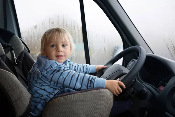 Söt liten pojke, unge rider stor husbil — Stockfoto