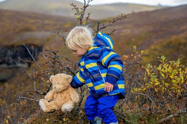 Criança feliz, segurando ursinho de pelúcia, posando na frente do namorado — Fotografia de Stock