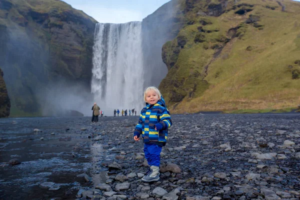 Küçük çocuk, Skogafo 'nun önündeki nehirde kayalarla oynuyor. — Stok fotoğraf
