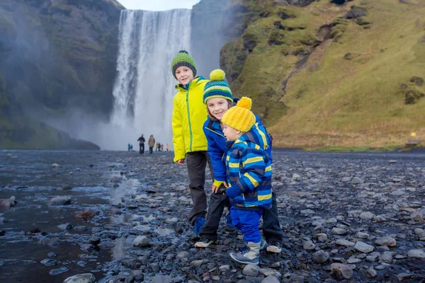 Bambino e fratelli, giocando con le rocce sul fiume in fro — Foto Stock