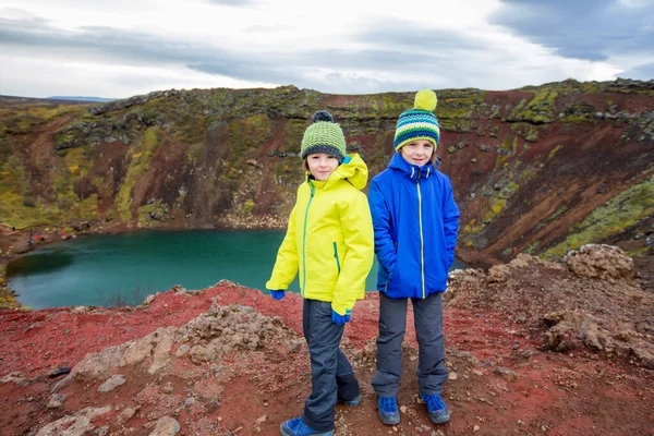 Gyerekek, fiúk, pózoljatok a Kerid kráter tó előtt Izlandon. — Stock Fotó