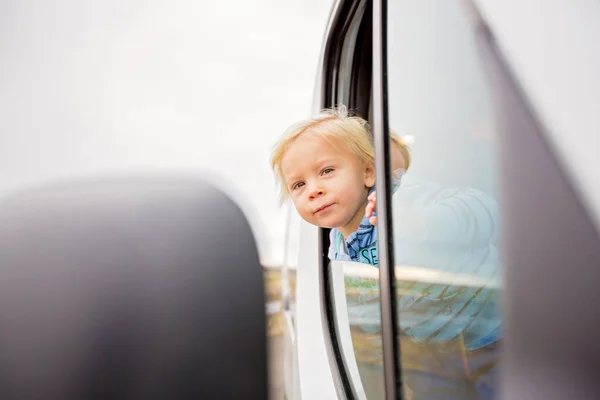可爱的蹒跚学步的男孩，透过车窗，欣赏着 — 图库照片