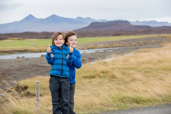 Niños, jugando en un camino cerca de vulcano inactivo en Snaefells —  Fotos de Stock