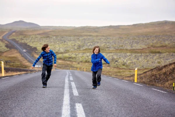 Děti běží na prázdné cestě v krásné přírodě v Snaefellsjo — Stock fotografie