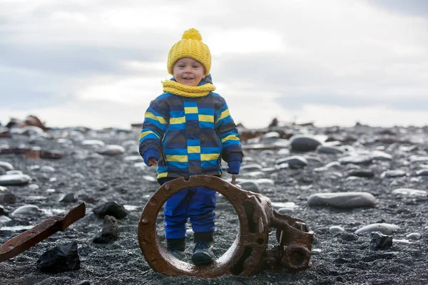 Kleiner Junge spielt mit Steinen am Strand in schöner Natur — Stockfoto