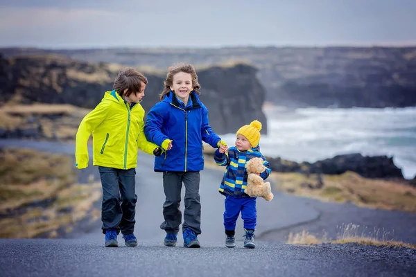Bambini, camminando su una strada curva vicino all'oceano nella bellissima natura — Foto Stock