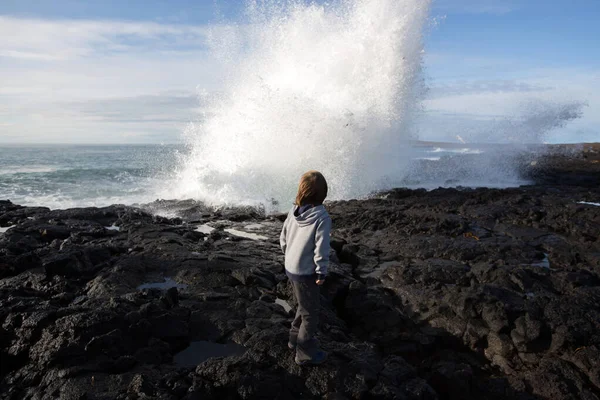 Kinderen kijken naar optreden golven crashen in rotsen op het zuidwesten — Stockfoto