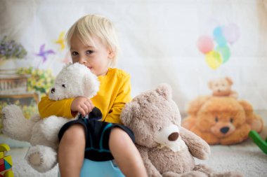 Sevimli Toddler çocuk, lazımlık eğitim, onun oyuncak ayı ile oynuyor 