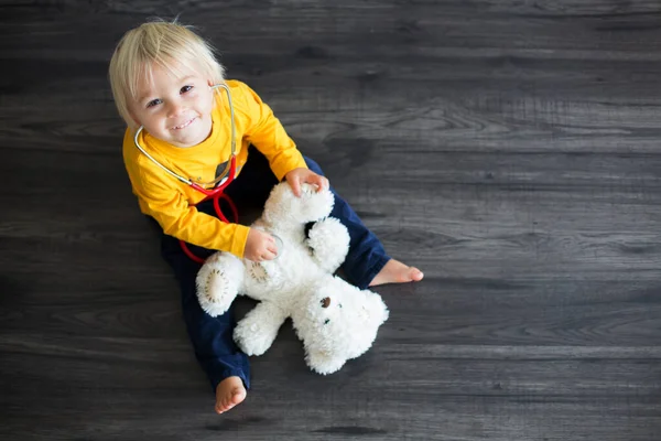 Sladké batole dítě, hrát si na doktora, vyšetření plyšového medvídka hračka — Stock fotografie