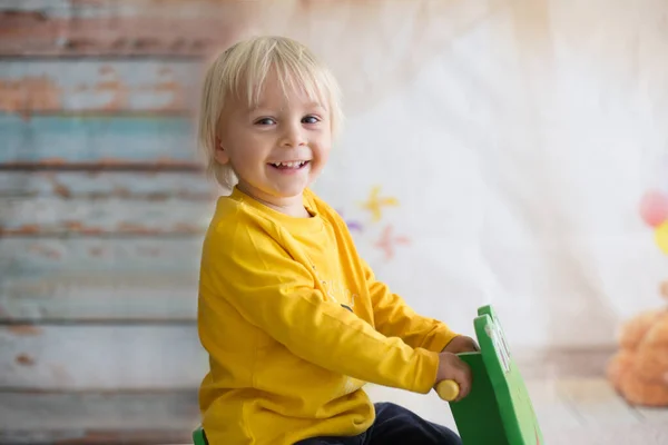 Klein schattig peuter jongen, spelen met schommel kikker swing thuis — Stockfoto