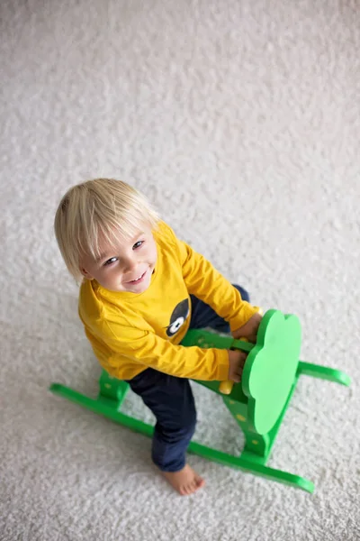 Pequeno menino bonito da criança, brincando com balanço sapo balanço em casa — Fotografia de Stock