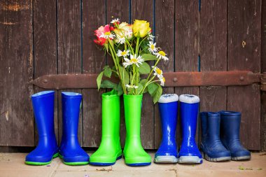 Bahçede güzel çiçekli lastik botlar.