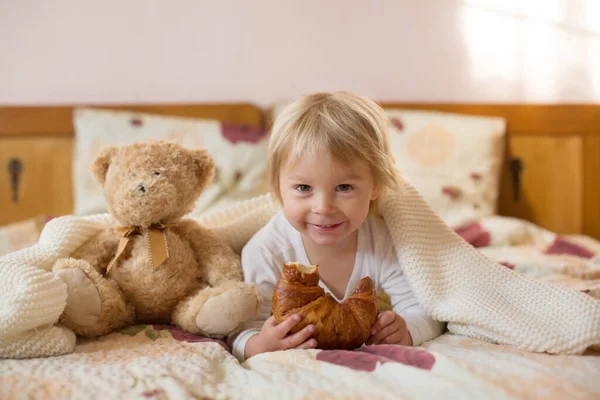 Cute Blonde Toddler Child Reading Book Eating Croissant Bed Laughing — Stock Photo, Image