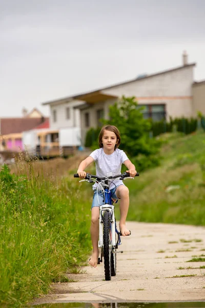 Dziecko Chłopiec Jazda Rowerze Błotnistej Kałuży Lato Deszczowy Dzień — Zdjęcie stockowe
