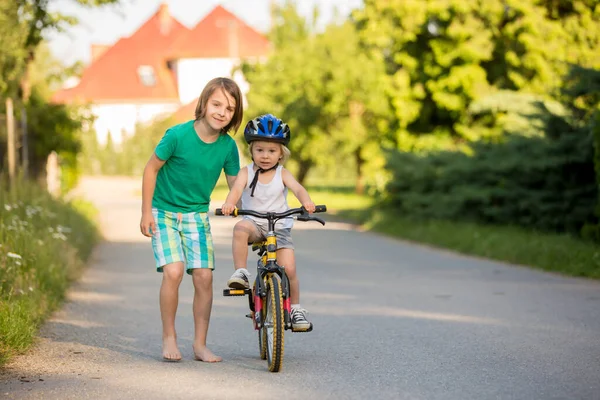 자전거타는 배우도록 동생을 자전거타는 가르쳐 — 스톡 사진