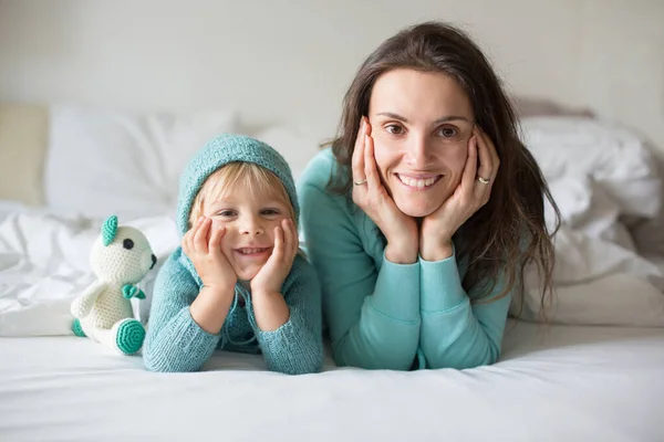 幸せな母親と子供 男の子 一致する服を着て ベッドに横たわって 幸せな笑顔 抱擁と毛布の下に隠れて — ストック写真