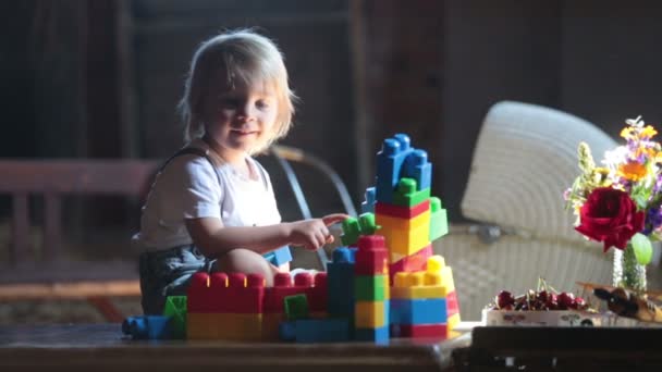 可爱的漂亮的孩子 金发的孩子 在舒适的阁楼房间里玩建筑块 充满了阳光 — 图库视频影像