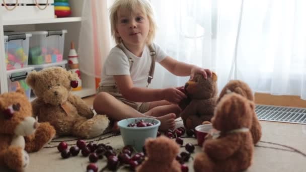 Küçük Sarışın Çocuk Tatlı Çocuk Evde Oyuncak Ayılarla Kiraz Yiyor — Stok video