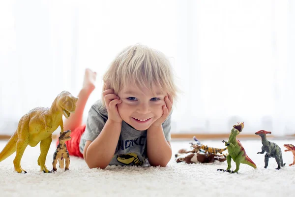 Blond Peuter Kind Spelen Met Dinosaurussen Thuis Mooi Zacht Achterlicht — Stockfoto