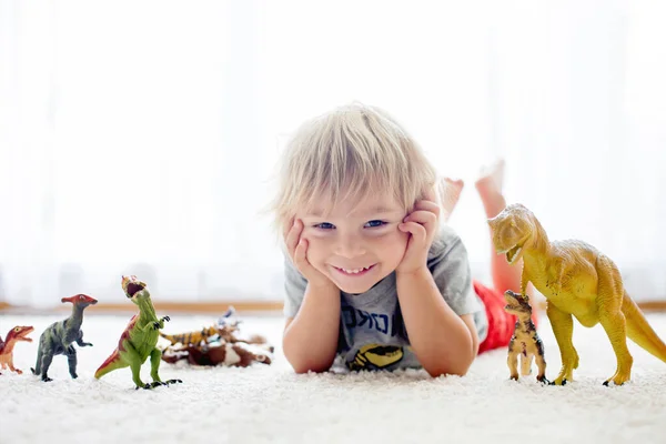 Blond Småbarn Leka Med Dinosaurier Hemma Fin Mjuk Bakgrundsbelysning — Stockfoto
